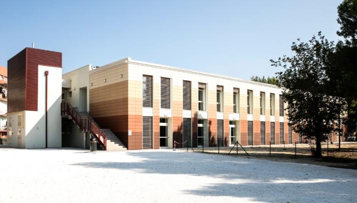 Image of a school building. Light coloured building.