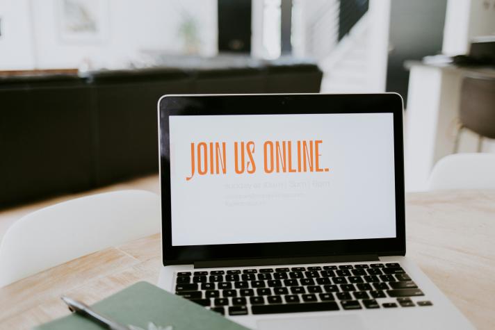 Photo of an open laptop with a white screen and a setence saying 'join us online'