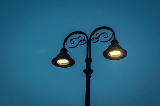 Image of a lamp post with two spotlights. Blue background