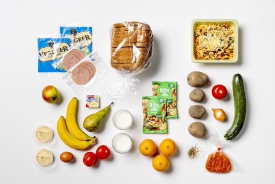 Photo of food placed on a white background. The picture contains fruits like banana and apple, vegetables like cucumber, carrots, onions, morron, as well as yogurt, salad and cheese. 