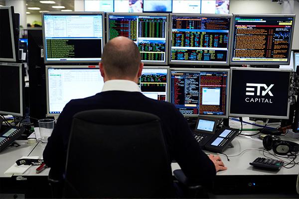 Trader working on in front of several computer screens